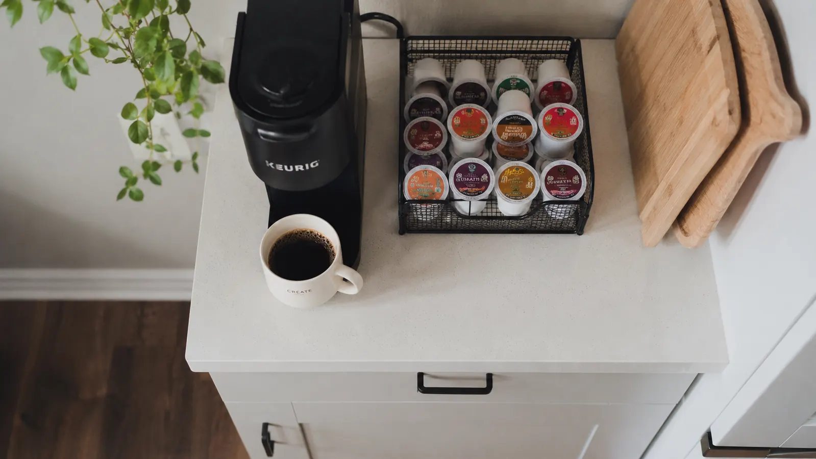 Overhead view of a Keurig K-Mini next to a coffee mug and a small pod holder on a narrow counter showing the complete coffee station footprint